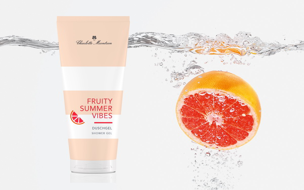 Fruity Summer Vibes Duschgel neben einer Grapefruit, die gerade ins Wasser fällt