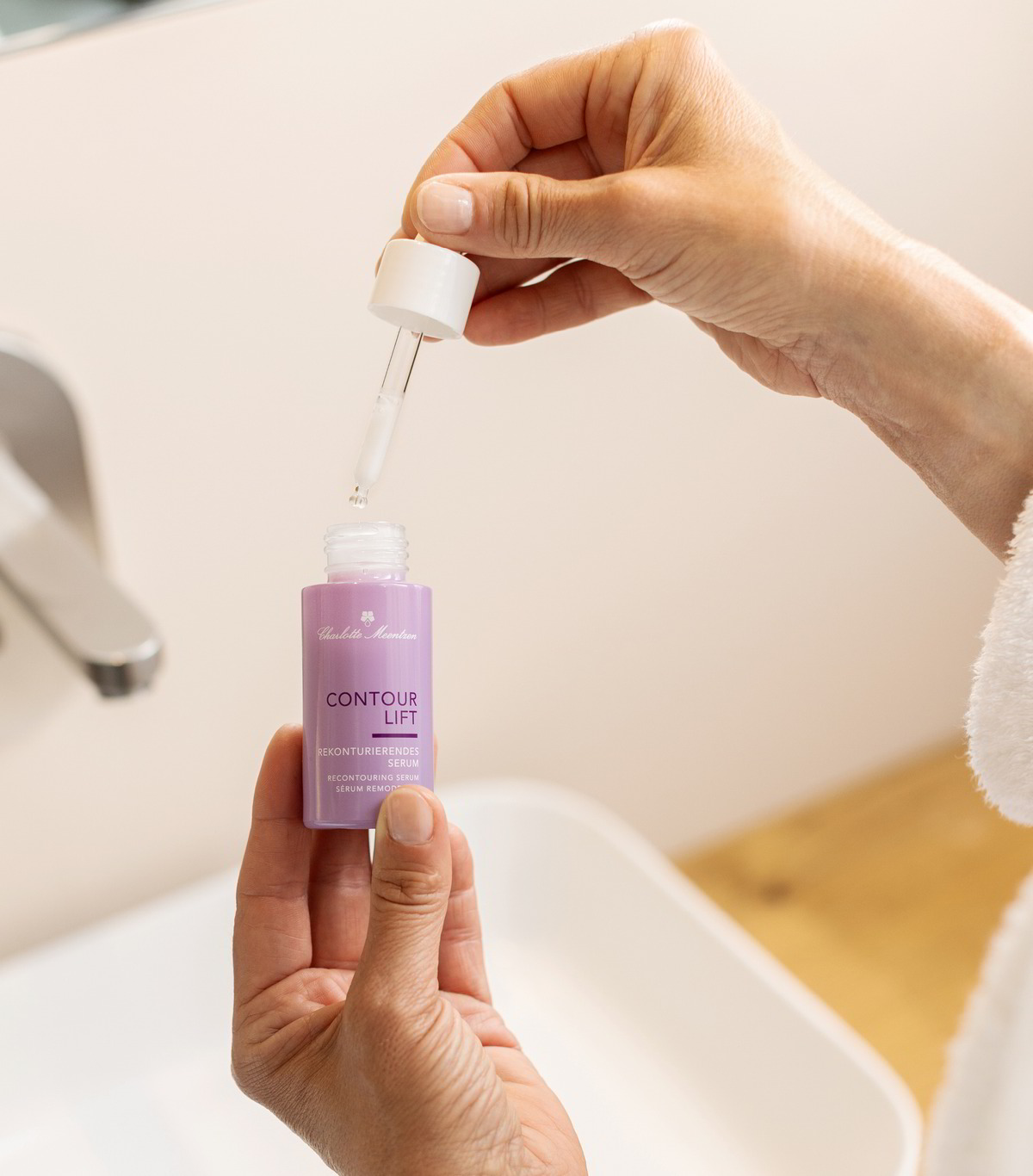 Person hält geöffnete Serumflasche in der Hand und in der anderen die Pipette.