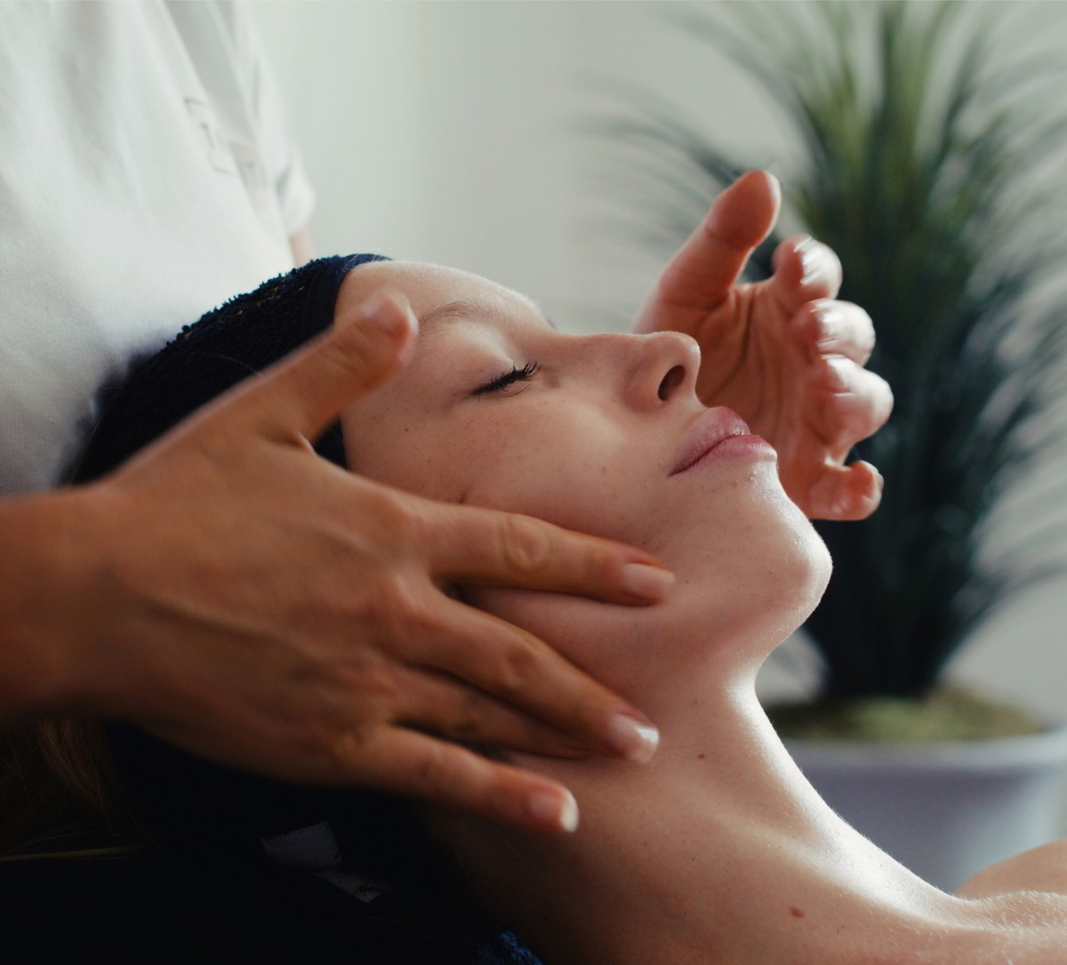 Eine Person erhält eine Gesichtsmassage, entspannt, mit sanften Händen und einem grünen Hintergrund.