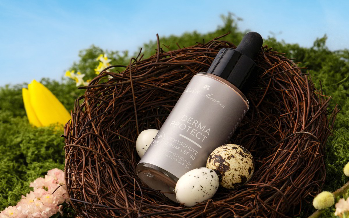 Ein Serum in einem Nest aus Zweigen, umgeben von Eiern und frischen Frühlingsblumen.
