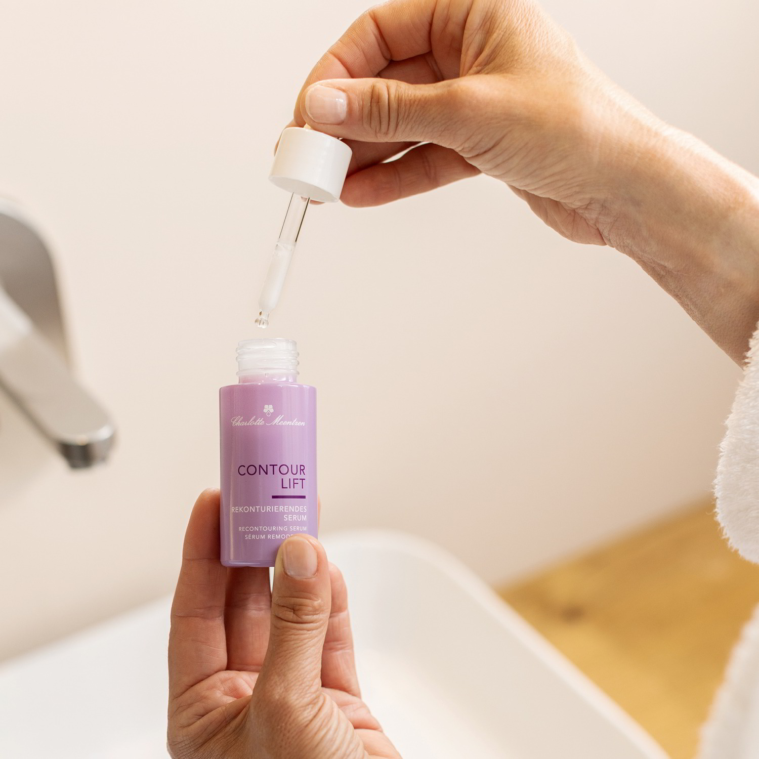 Frau hält die Serumflasche sowie die Pipette in der Hand.