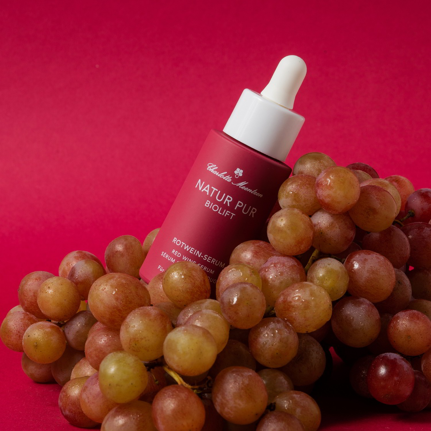 Natur Pur BIOLIFT red wine serum on grapes against a red background